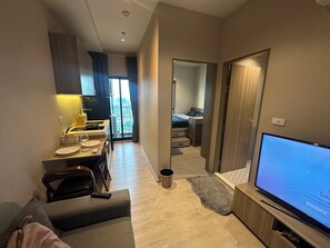 A modern apartment with a dining area, a living room with a TV, a kitchen, and a bedroom with a view. - City View Condo - Pool, Gym – BTS Talat Phlu (Bang Chak, Phra Khanong)