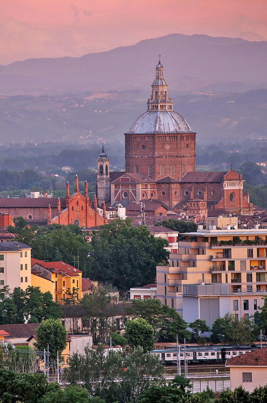 A historic church with a prominent dome and bell tower, surrounded by residential buildings and greenery.