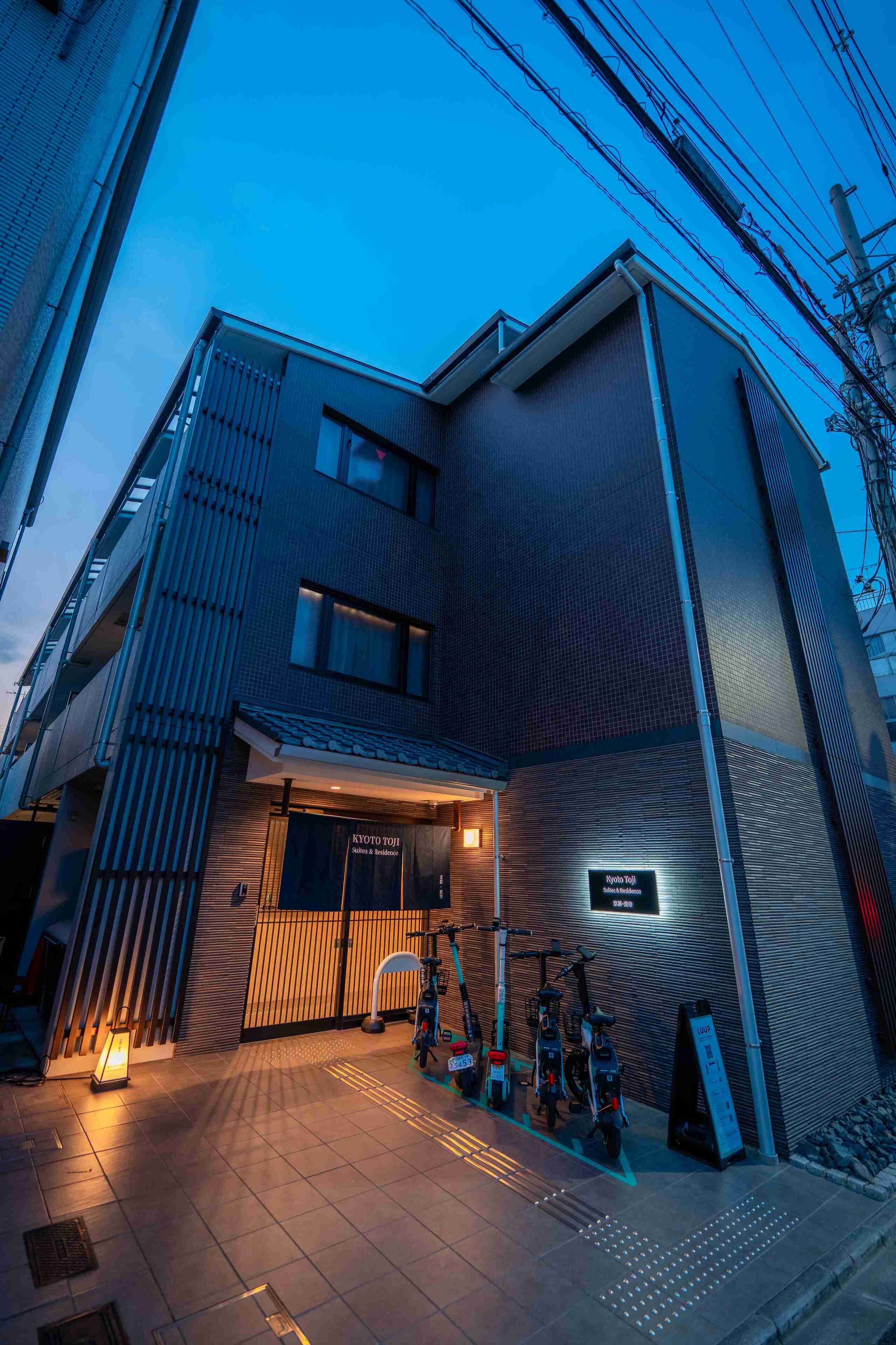A modern building with a tiled entrance and electric scooters parked outside.