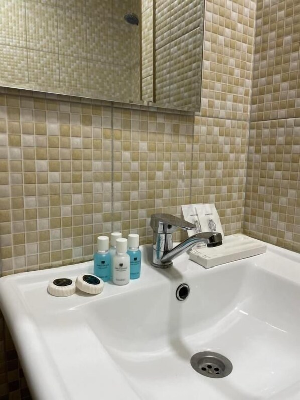 A bathroom with a white sink, a mirror, and tiled walls. - Best Center Nizami Hotel (Baku)