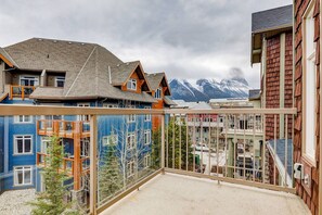 Un immeuble résidentiel doté d’un balcon donnant sur un paysage montagneux.