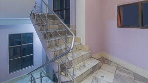 A staircase with metal railings leading to an upper floor. - Hotel O by OYO Am Bed And Breakfast (Shillong)