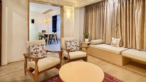 Una sala de estar moderna con un sofá, dos sillones, una mesa de comedor y una mesa de centro.