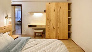 Un dormitorio con cama, escritorio y armario.