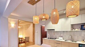 Cocina moderna con comedor, que incluye luces colgantes, estufa integrada y lavavajillas.