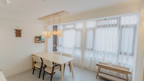 Un comedor moderno con una mesa blanca, sillas y un banco de madera.