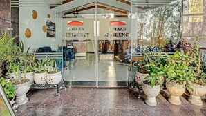 L’entrée d’un hôtel, avec une porte en verre, des plantes en pot et une enseigne indiquant « VHAAN RESIDENCY ».
