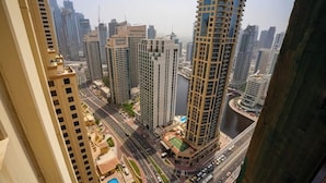 A high-rise building with a river in the foreground and other high-rise buildings in the background. - WaHa WoW (Dubai)