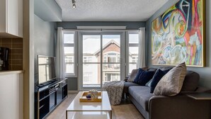 En moderne stue med sofa, sofabord og fjernsyn.