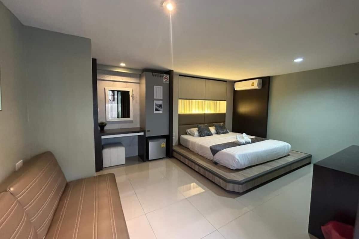 Une chambre d’hôtel moderne, dotée d’un grand lit, d’un bureau et d’un coin salon.