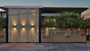 Un bâtiment moderne doté d’une façade métallique et d’une entrée sécurisée par un portail.