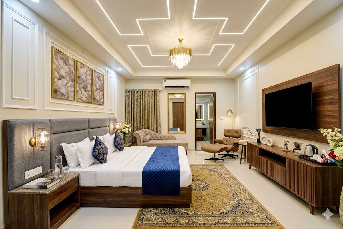 A hotel room with a large bed, a TV, a desk, and a chair.