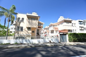 A residential building with multiple floors, balconies, and a gated entrance. - 4BR Villa with A/C -High speed Internet • 20mts from Beach • Rooftop Sunset Spot (Flic en Flac)