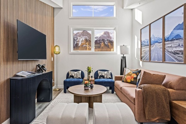 Step into the living area, which features a large smart TV for entertainment and also highlights stunning mountain views. It`s ideal for gathering with loved ones as the open-concept layout provides direct access to the kitchen, dining area, and private p