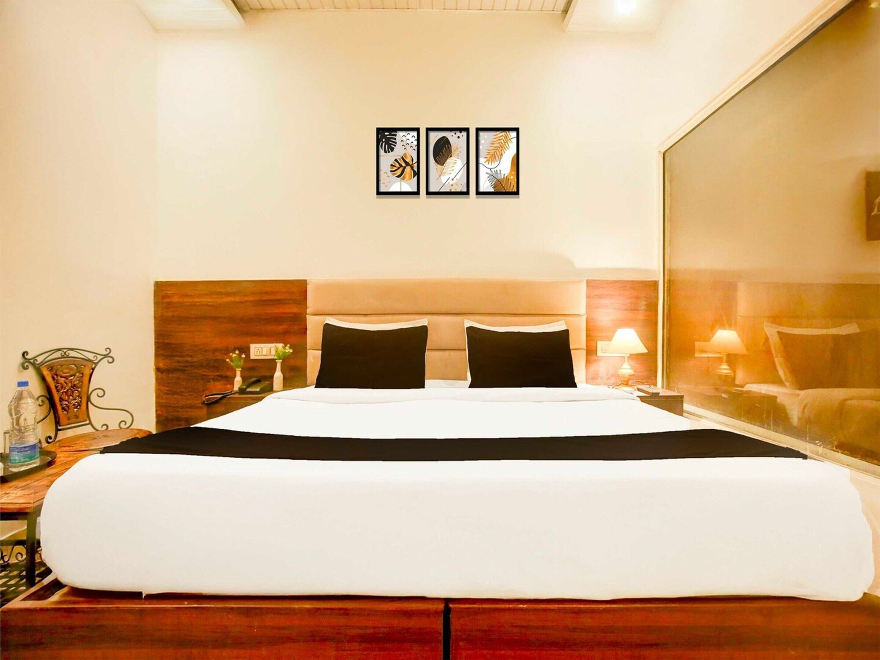 Een hotelkamer met een groot bed, twee nachtkastjes, en een raam met uitzicht.