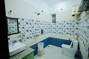 A bathroom with a sink, toilet, and shower. - BUDDHA DHAM (Vrindavan)