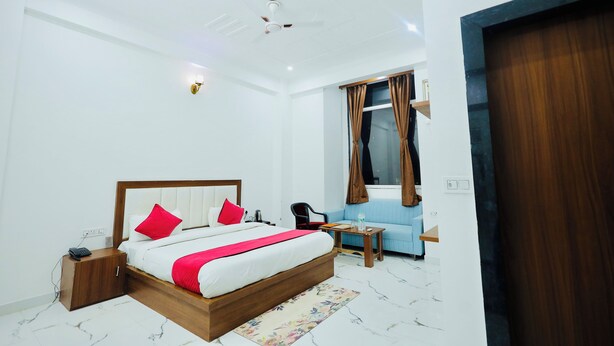 Una habitación de hotel moderna con una cama grande, un escritorio, una silla y un sofá.
