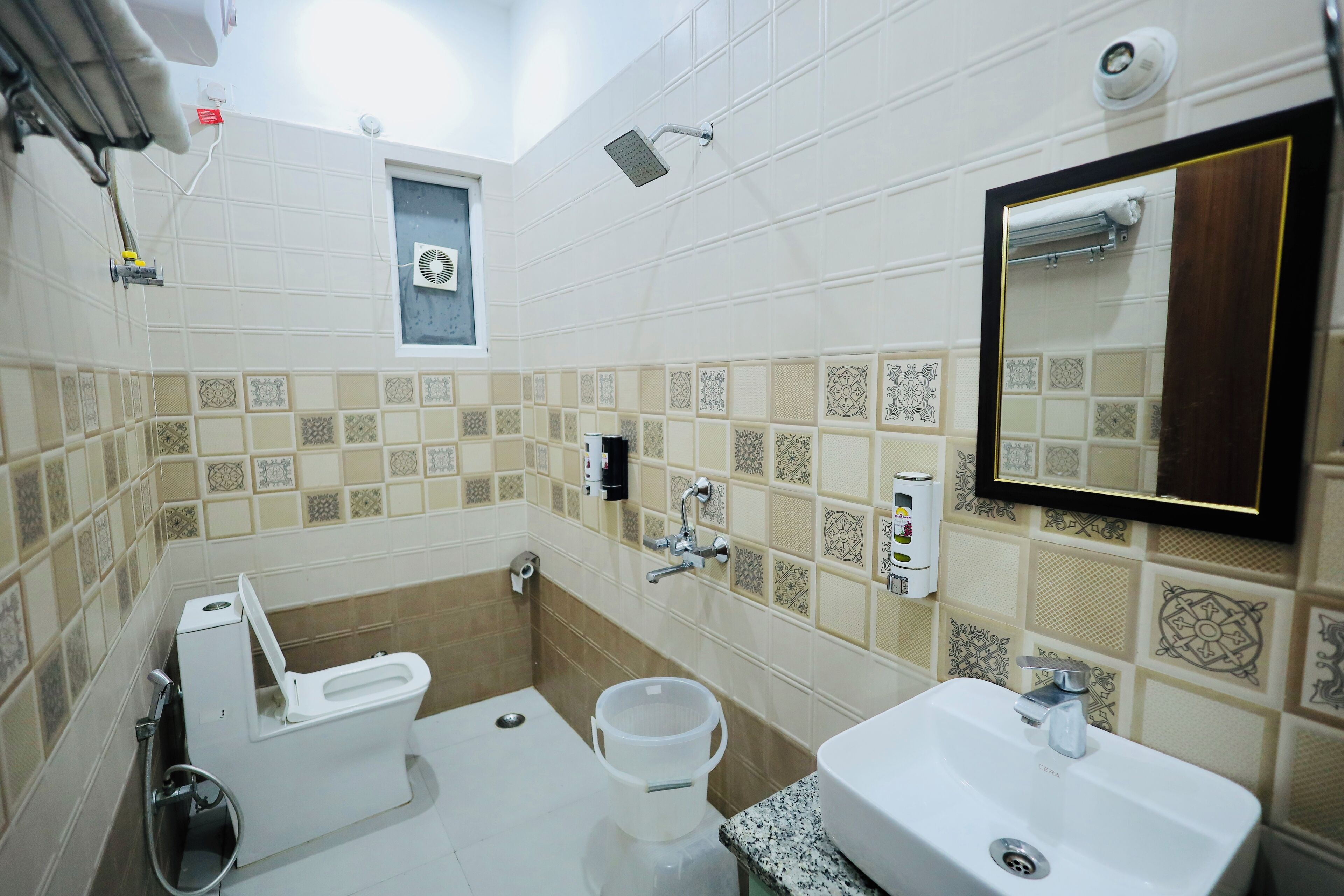 A bathroom with a toilet, bidet, sink, and a mirror.