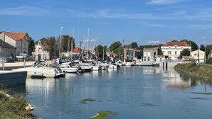 Een jachthaven met aangemeerde boten, omringd door gebouwen met rode dakpannen.