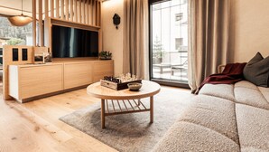 A modern living room with a wooden TV stand, a round coffee table, and a sofa. - Apart  Bieles NEU by Interhome (Kauns)