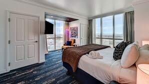 Una camera d'albergo con un letto grande, vista sulla città e un balcone affacciato sul panorama urbano.