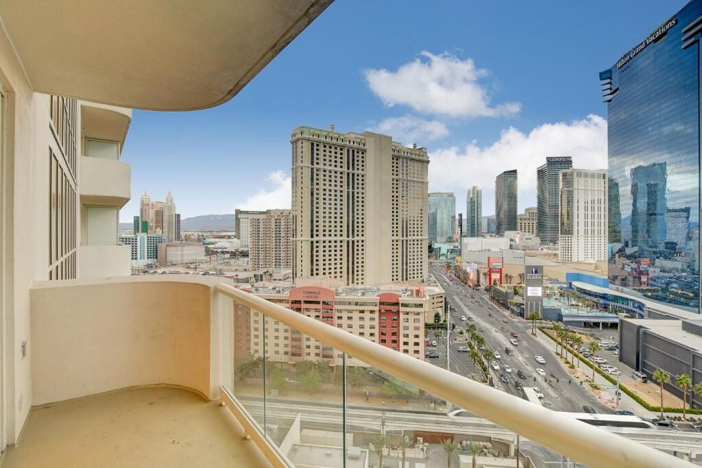 A high-rise building with a view of a cityscape, including several other tall buildings and a busy street below.
