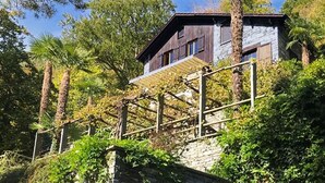 Et moderne hus med træfacade, stensokkel og en trætrap op til døren.