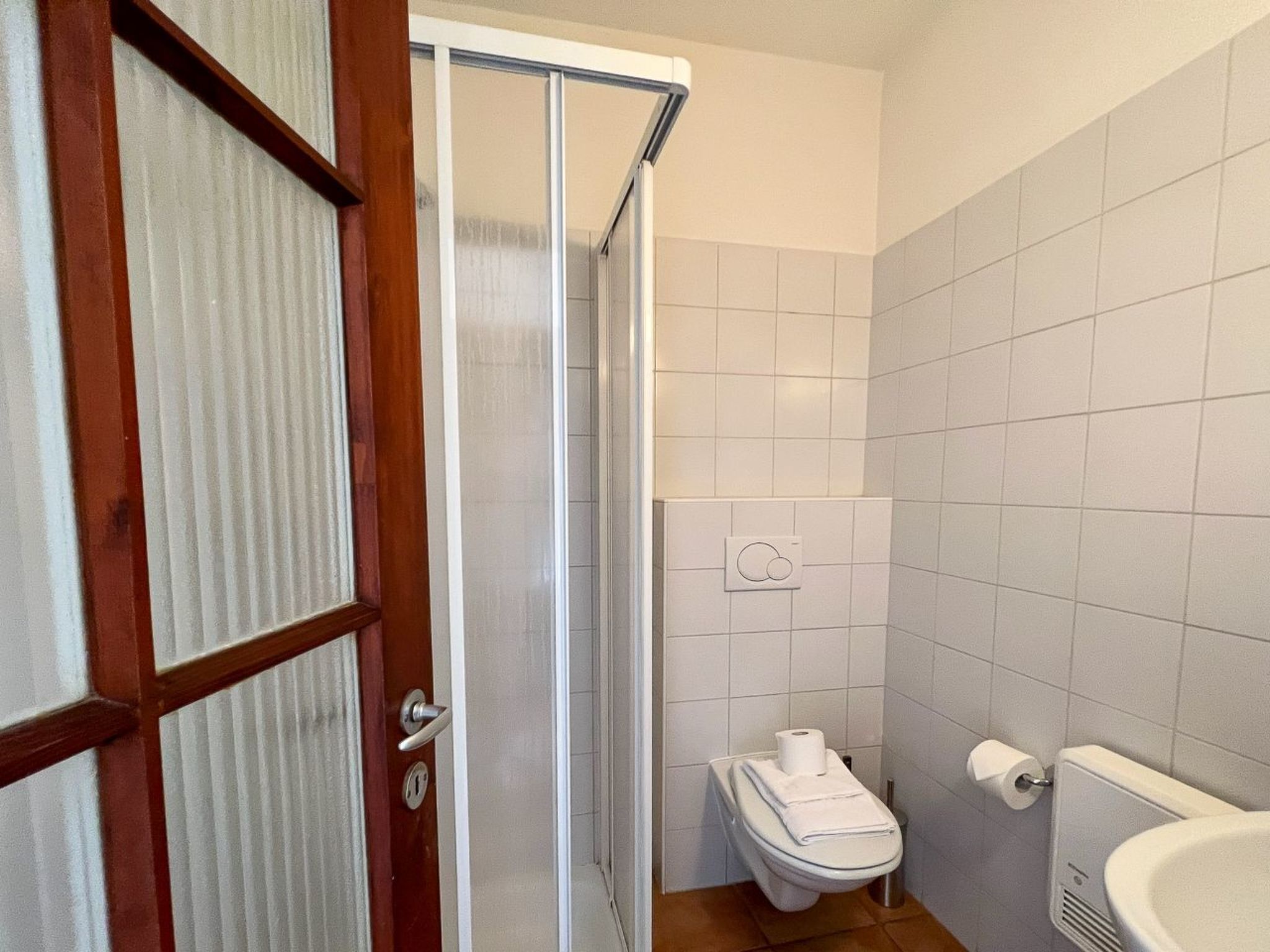 Une salle de bain avec des toilettes, un lavabo et une douche.