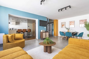 A modern living room with a sofa, coffee table, and a dining area with chairs and a table. - Town House for 6 people (Reims)