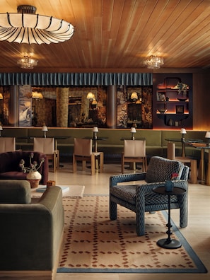 A modern interior with a bar area, seating, and decorative elements. - 1BR Suite w/ Private Balcony | Pool + Terrace + Restaurant | The Code (Austin)