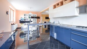 A modern kitchen with a central island, blue cabinets, and a white backsplash. - 3 bedroom gorgeous home in Torre Le Nocelle (Torre Le Nocelle)
