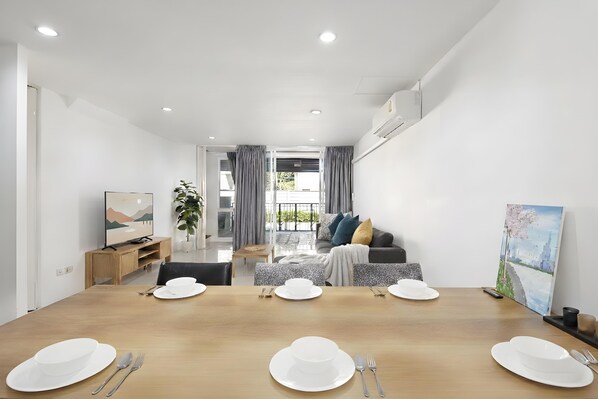 Un salon moderne avec un coin repas aménagé pour quatre personnes.