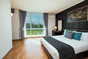 Une chambre à coucher moderne avec un grand lit, une vue sur un lac et un mur d’accent en briques noires.