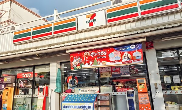 Un magasin de proximité 7-Eleven avec une grande enseigne annonçant une promotion.