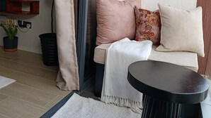En mysig sittgrupp med en soffa, kuddar och ett litet bord.