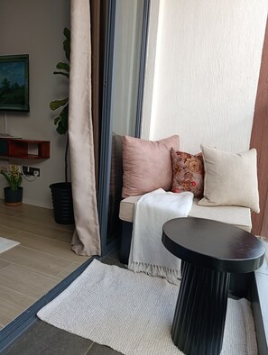 Eine gemütliche Sitzecke mit einer Couch, Kissen und einem kleinen Tisch.