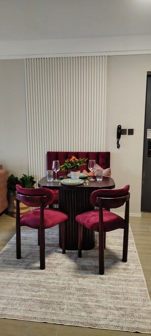 Ein Essbereich mit einem runden Tisch, vier Stühlen und einer Blumenvase.