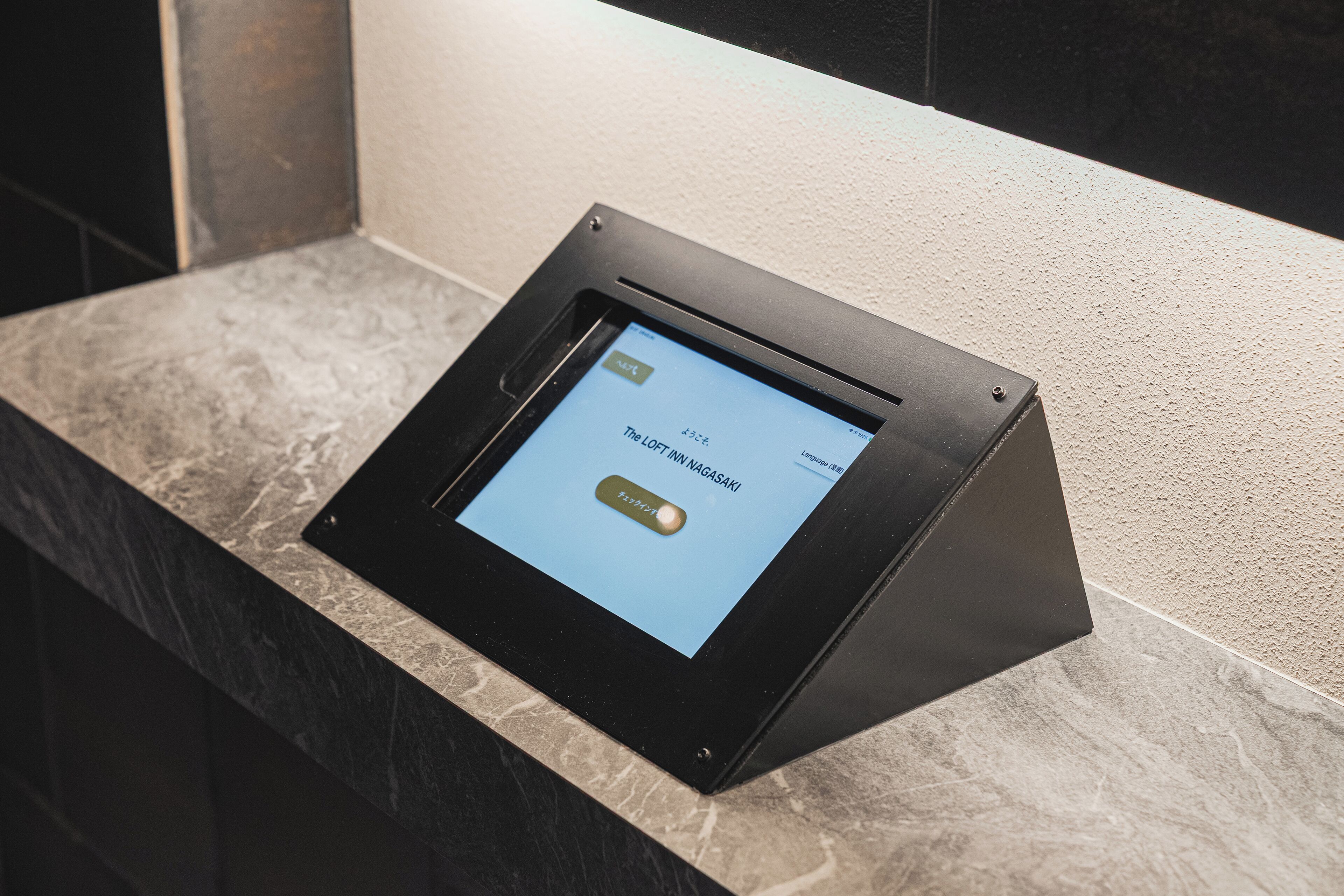 A digital kiosk with a screen displaying text and a button.