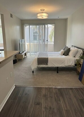 A bedroom with a bed, a TV, a balcony, and a ceiling light. - 1 Bedroom Paradise Near Venice Beach (Marina del Rey)
