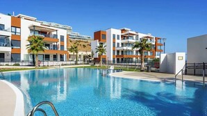 Une piscine avec, en arrière-plan, des immeubles d’appartements modernes.