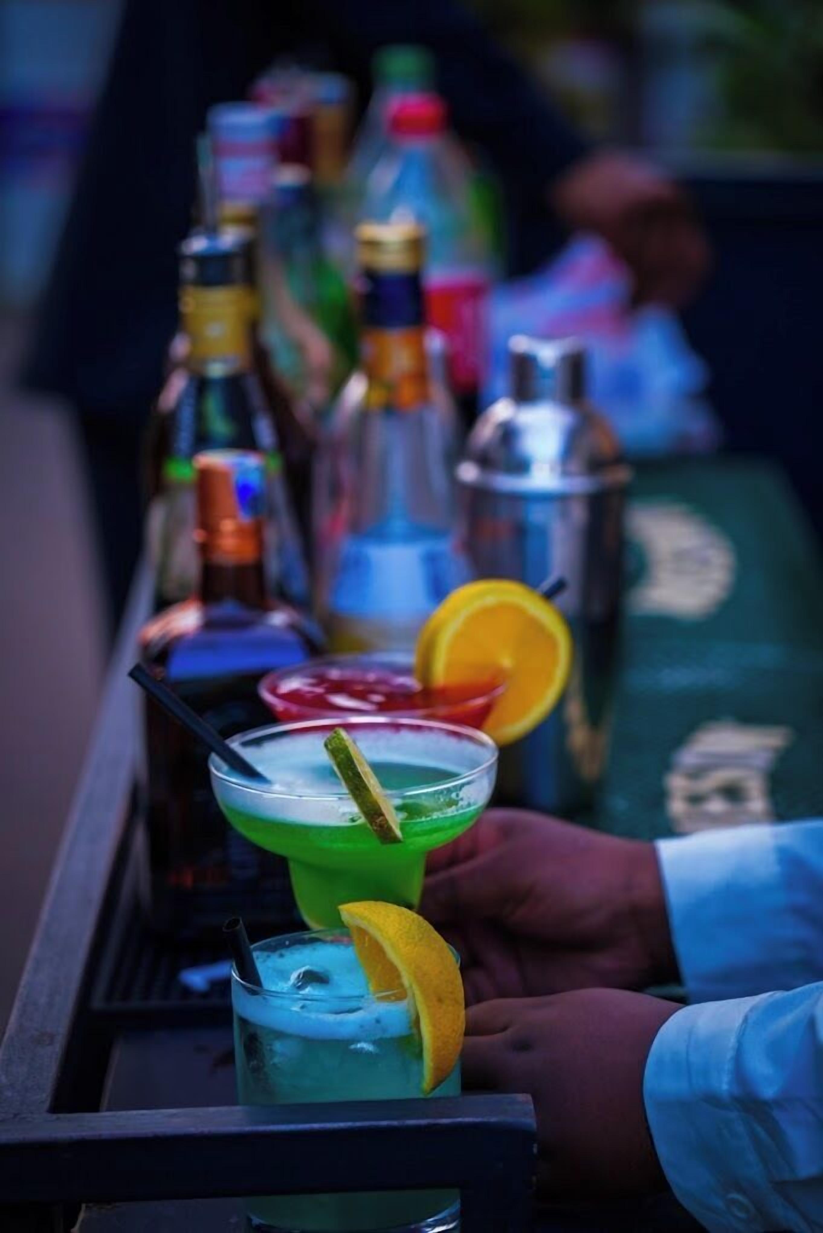 Zona de bar con diferentes botellas y vasos de bebidas.