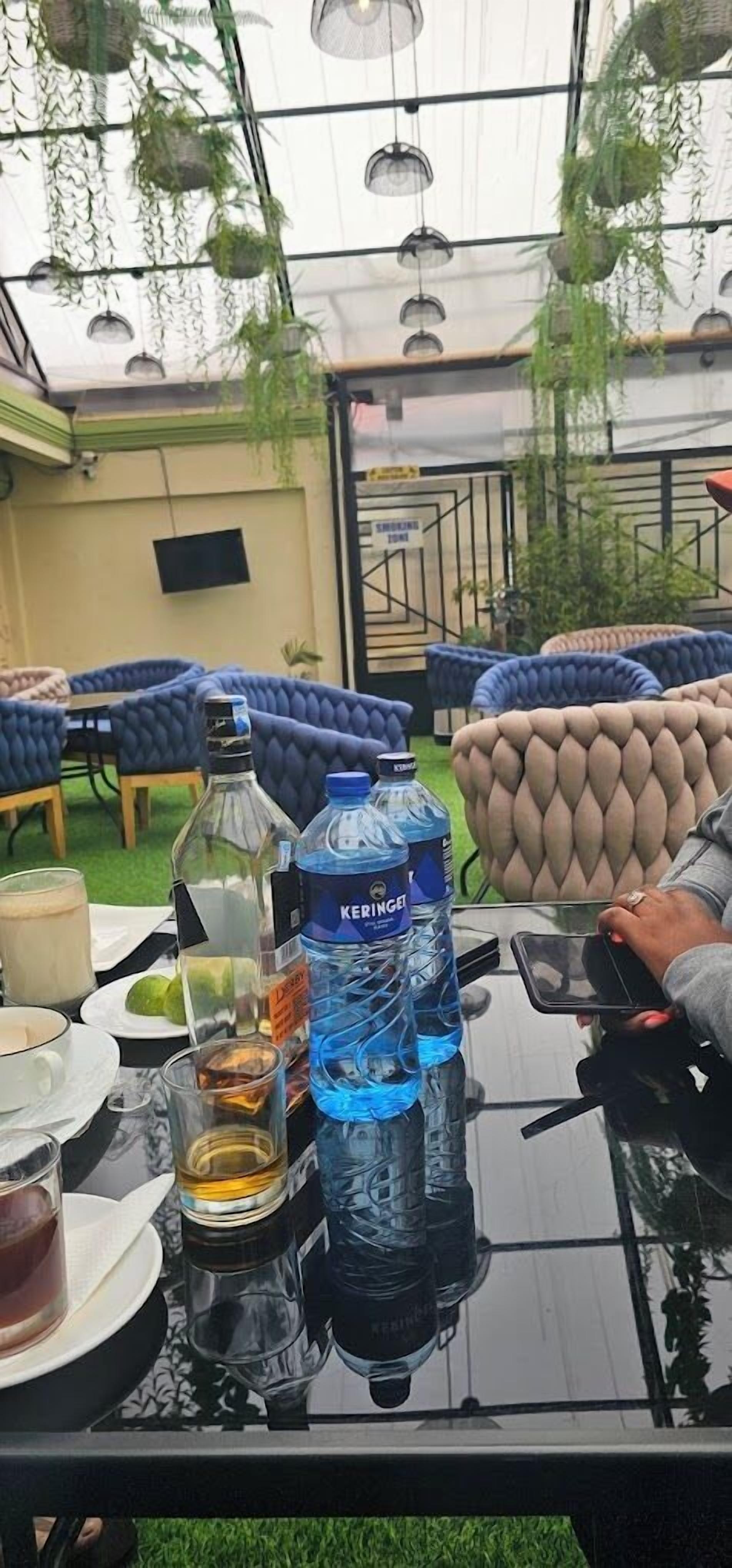 A table with drinks, a bottle of water, and a tablet.