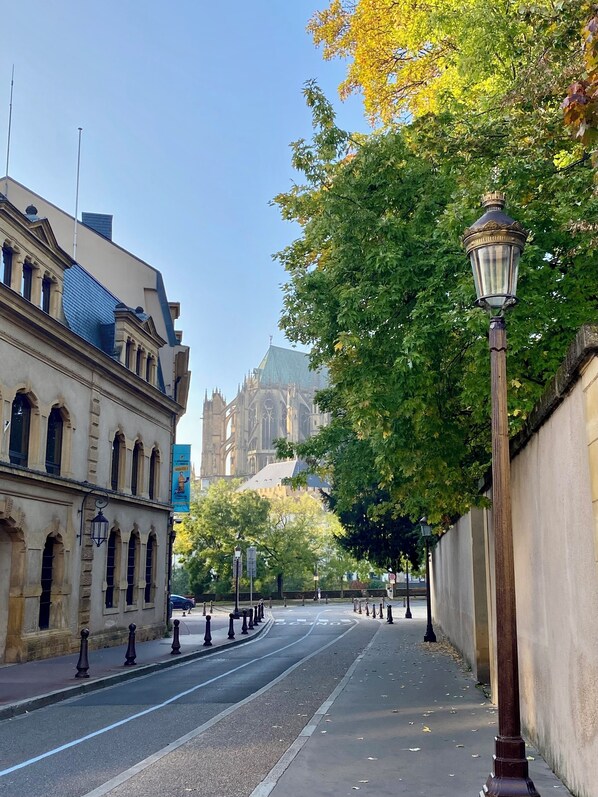 Una calle con un edificio histórico a la izquierda y una gran catedral al fondo.