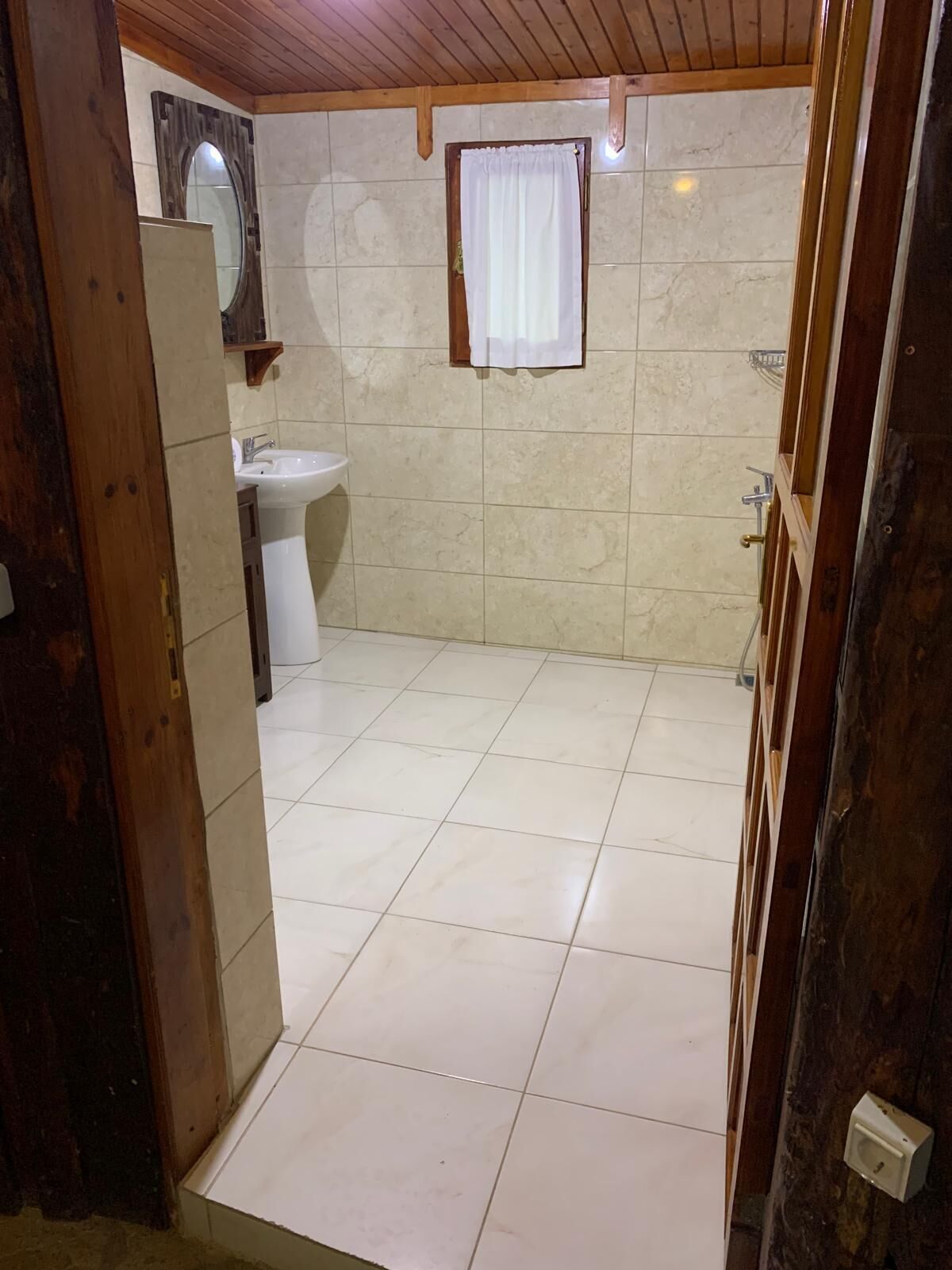 A bathroom with a sink, mirror, and tiled floor.