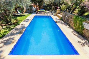 Una piscina al aire libre de temporada, sombrillas