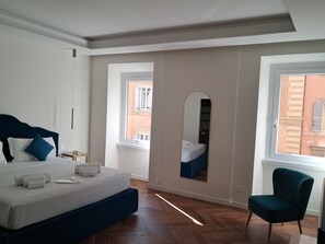 A bedroom with a bed, a chair, a mirror, and a window. - Sistina Home Collection (Rome)
