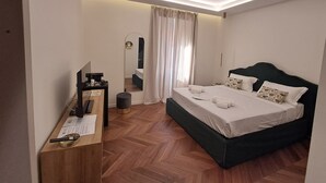 Une chambre d’hôtel moderne avec un grand lit, un bureau équipé d’un ordinateur et un miroir.