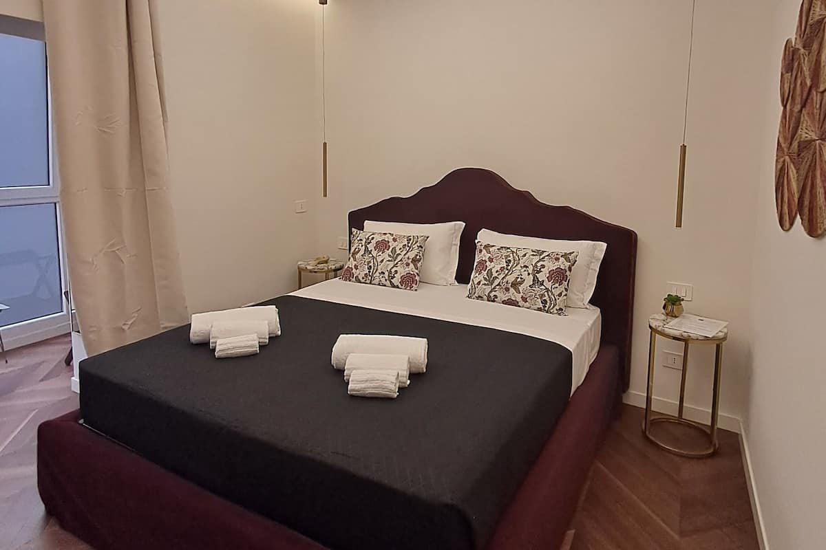 Un dormitorio moderno con una cama grande, una mesita de noche y vistas al exterior.