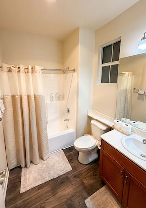 A bathroom with a bathtub, toilet, and sink. - One Bedroom Apartment Marina Del Rey (Marina del Rey)