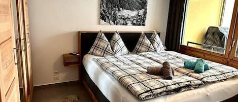 Une chambre à coucher moderne avec un grand lit, une armoire en bois, un tapis et un tableau au mur.